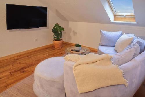 uma sala de estar com um sofá e uma televisão de ecrã plano em Ferienwohnung “Mount Meißner” em Germerode