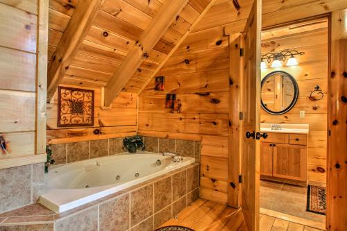 La salle de bains est pourvue d'une baignoire et de murs en bois. dans l'établissement Smoky Mountain Cabin about 5 Mi to Pigeon Forge, à Sevierville