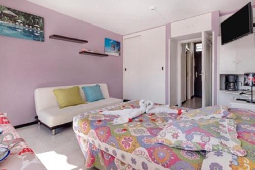 una camera da letto con un letto e un divano di Olimpia 3 a Playa de las Americas