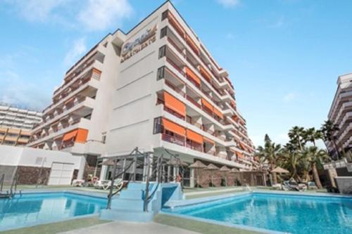 un edificio con una piscina di fronte a un edificio di Olimpia 3 a Playa de las Americas