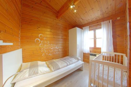 ein Schlafzimmer mit einem Bett in einer Holzwand in der Unterkunft Ferienhaus Nordsee in Dorum Neufeld