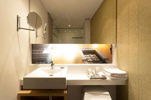 W łazience znajduje się umywalka i lustro. w obiekcie Hotel bh Bicentenario w mieście Bogota