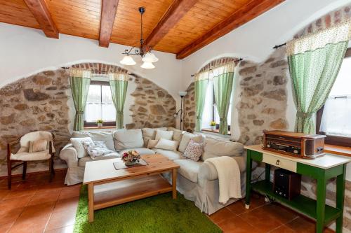 ein Wohnzimmer mit einem Sofa und einem Tisch in der Unterkunft Chalupa Na peci in Želnava