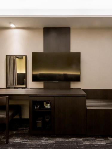 a room with a desk with a mirror and a table at KKR Hotel Osaka in Osaka