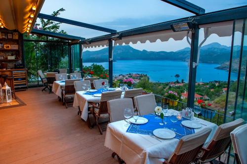 a restaurant with tables and chairs with a view at Swan Lake Hotel - Adult Only in Selimiye