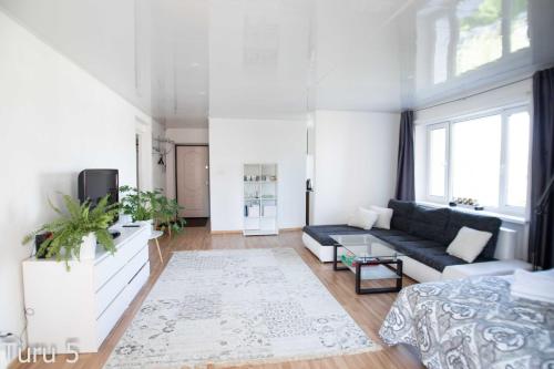a living room with a couch and a tv at City Center Turu str apartments, parking, Tartu Home in Tartu