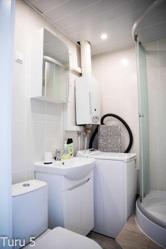 a white bathroom with a toilet and a sink at City Center Turu str apartments, parking, Tartu Home in Tartu