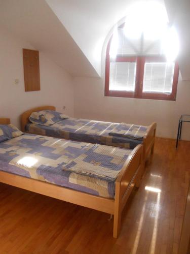 two beds in a room with two windows at Nikolic Apartments - Ohrid City Centre in Ohrid