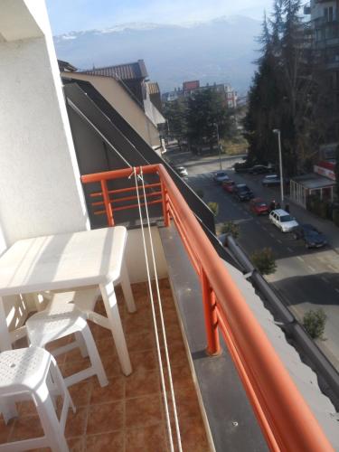 a white chair on a balcony with a view of a street at Nikolic Apartments - Ohrid City Centre in Ohrid