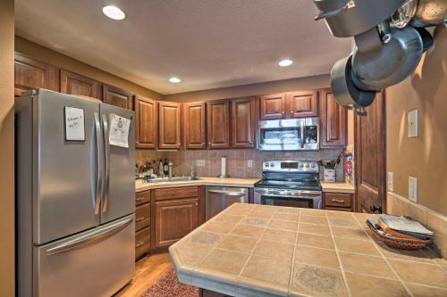 a kitchen with wooden cabinets and a stainless steel refrigerator at Charming Big Sky Ski Nook Less Than 1 Mile to Ski Resort! in Big Sky