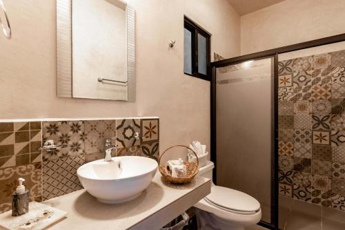 y baño con lavabo, aseo y ducha. en Hotel Colonial Zaci by GuruHotel en Valladolid