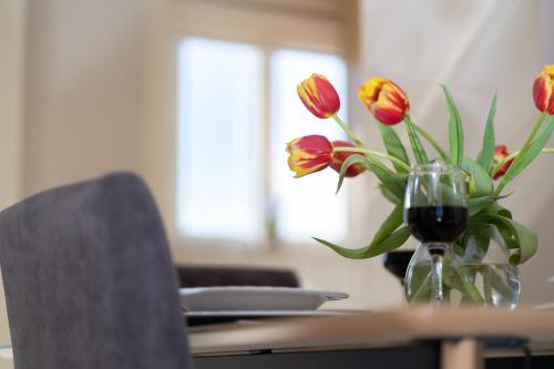 a vase of red tulips sitting on a table at Helios Residence in Chania
