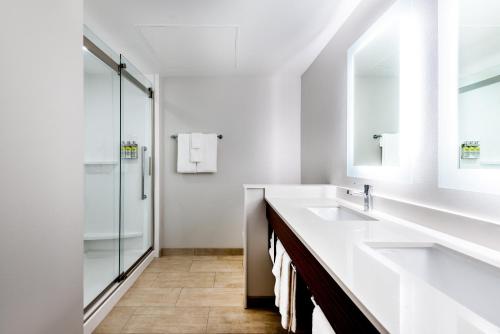 a white bathroom with a sink and a shower at Holiday Inn Express & Suites Santa Ana - Orange County, an IHG Hotel in Santa Ana