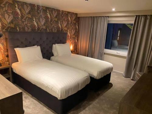 a hotel room with two beds and a window at Wildes Inns in Chesterfield