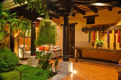 a living room with a couch and a table with plants at Hotel Meson del Valle by AHS in Antigua Guatemala
