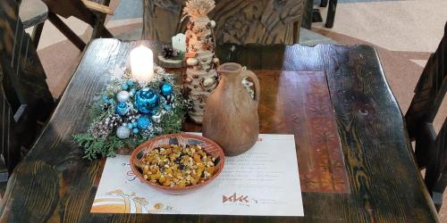 einen Tisch mit einer Vase und einer Schüssel Essen drauf in der Unterkunft Hotel Veles in Zolotonosha