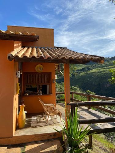 un porche de una casa con una mesa y una silla en Pousada Fecho da Serra en Capitólio