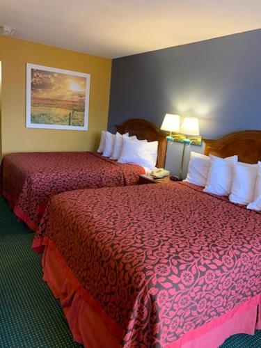 a hotel room with two beds and two lamps at Days Inn by Wyndham Jonesboro AR in Jonesboro