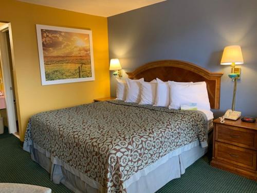 a hotel room with a large bed with white pillows at Days Inn by Wyndham Jonesboro AR in Jonesboro
