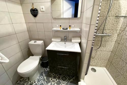 a bathroom with a toilet and a sink and a shower at Hotel Le Magnan in Avignon