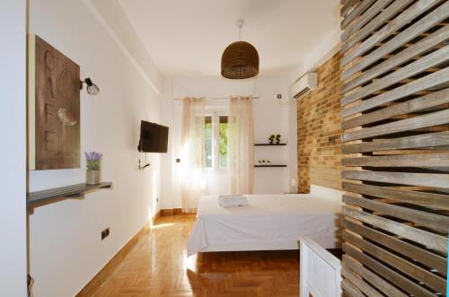 a bedroom with a bed and a brick wall at A modern rustic cosy apartment at the foot of Mount Lycabettus in Athens