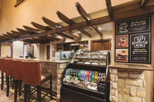 a restaurant with a counter with food and drinks at Hyatt Place Fort Worth Stockyard in Fort Worth