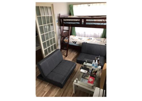een woonkamer met een bank en een stapelbed bij Stay Snnabe / Vacation STAY 52638 in Kumamoto