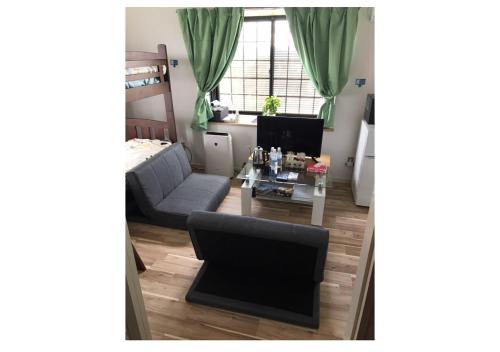 ein Wohnzimmer mit einem Sofa und einem Tisch in der Unterkunft Stay Snnabe / Vacation STAY 52638 in Kumamoto