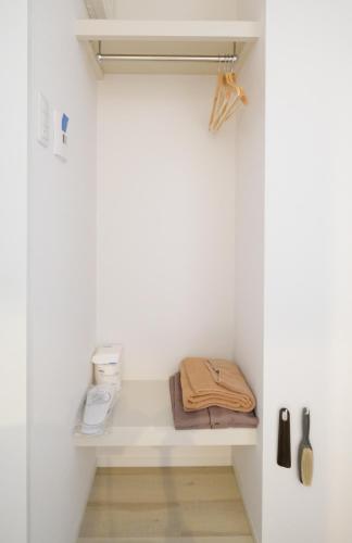 a walk in closet with a white wall at Cozy Inn OTARU in Otaru