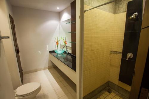 La salle de bains est pourvue d'une douche, de toilettes et d'un comptoir en verre. dans l'établissement Sang Serene House, à Chiang Mai