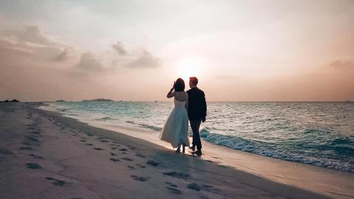 a man and a woman standing on the beach at Bliss Dhigurah in Dhigurah