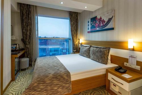 a hotel room with a bed and a large window at Dies Hotel in Diyarbakır