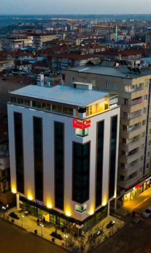 a large white building with a red sign on it at Dies Hotel in Diyarbakır