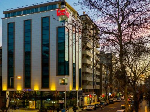 a tall building on a city street with cars at Dies Hotel in Diyarbakır