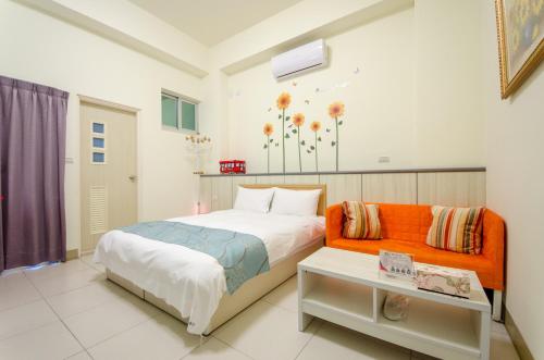 a bedroom with an orange bed and a table at 花蓮自由行民宿 in Hualien City