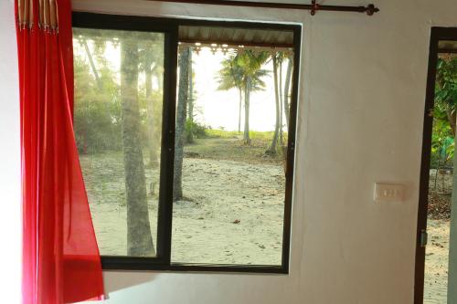 a window in a room with a view of a beach at Marari Baiju's Homestay in Mararikulam