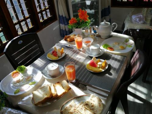 a table with plates of breakfast food on it at Lavendra Guset House in Adams Peak