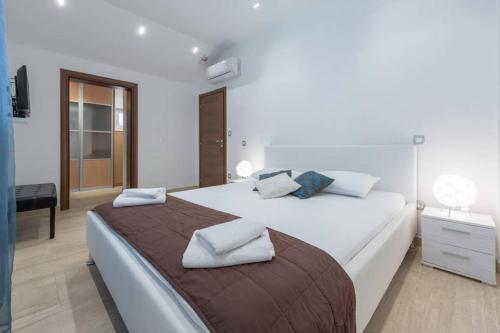 - une chambre avec un grand lit et des serviettes dans l'établissement Villa Mlini with private Pool and Sea view, à Mlini