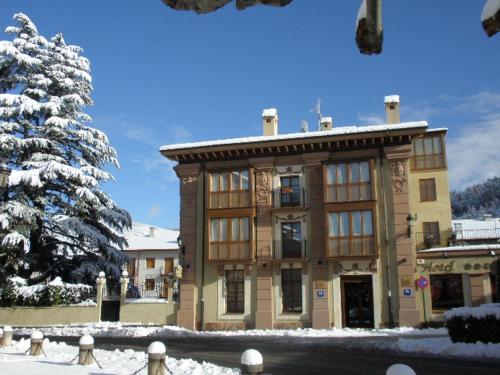 un edificio con un árbol cubierto de nieve delante de él en Palacio Azcárate Hotel, en Ezcaray