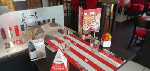 a table with two glasses and a book on it at Kyriad Aix Les Milles - Plan de Campagne in Bouc-Bel-Air