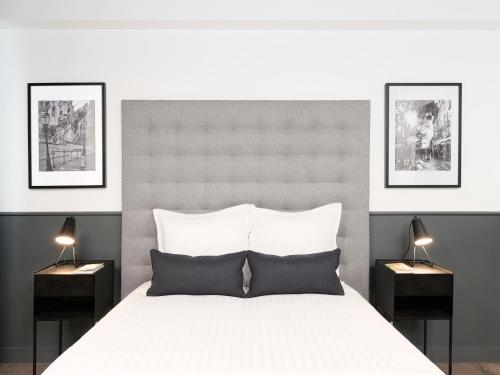 a bedroom with a large white bed with two night stands at LivinParis - Luxury AC 3 Bedrooms Le Marais I in Paris