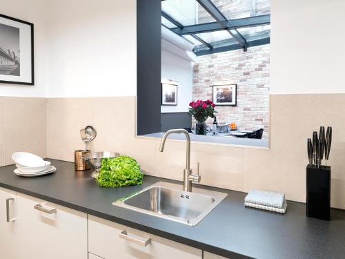 una cucina con lavandino e muro di mattoni di LivinParis - Luxury AC 3 Bedrooms Le Marais I a Parigi
