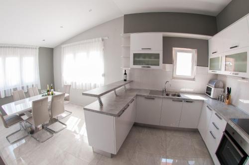 a kitchen with white cabinets and a counter top at Apartments Anita in Split