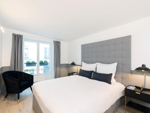 une chambre avec un grand lit blanc et une fenêtre dans l'établissement LivinParis - Luxury 4 Bedrooms Le Louvre I, à Paris