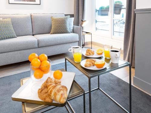 - un salon avec une table basse et 2 plateaux de pain et d'oranges dans l'établissement LivinParis - Luxury 4 Bedrooms Le Louvre I, à Paris
