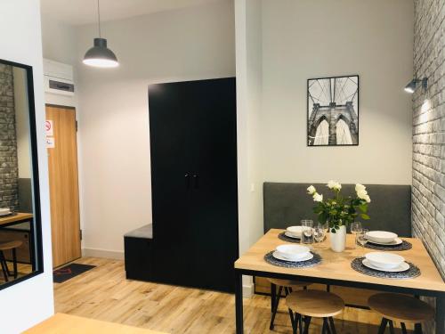 a dining room with a table and a black door at Property Apart - Soft Lofty Legnicka Centrum in Wrocław