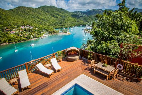 a deck with a view of the water and a river at Villa On The Bay - Relaxed Elegance in Marigot Bay
