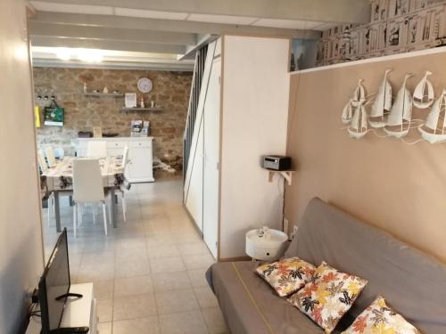 een woonkamer met een bank en een eetkamer bij La Glycine in Fouesnant