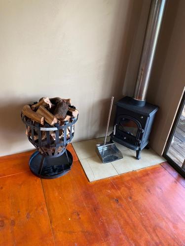 a room with a wooden floor with a wood stove at Pilot's Cabin, El Mirador Airfield in Champagne Valley