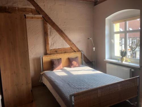 a bedroom with a bed with blue sheets and a window at Apartament przy Rynku 2 in Połczyn-Zdrój